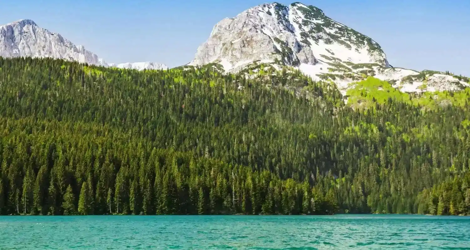 Tirkizna voda Crnog jezera ispod sniježnog planinskog vrha 