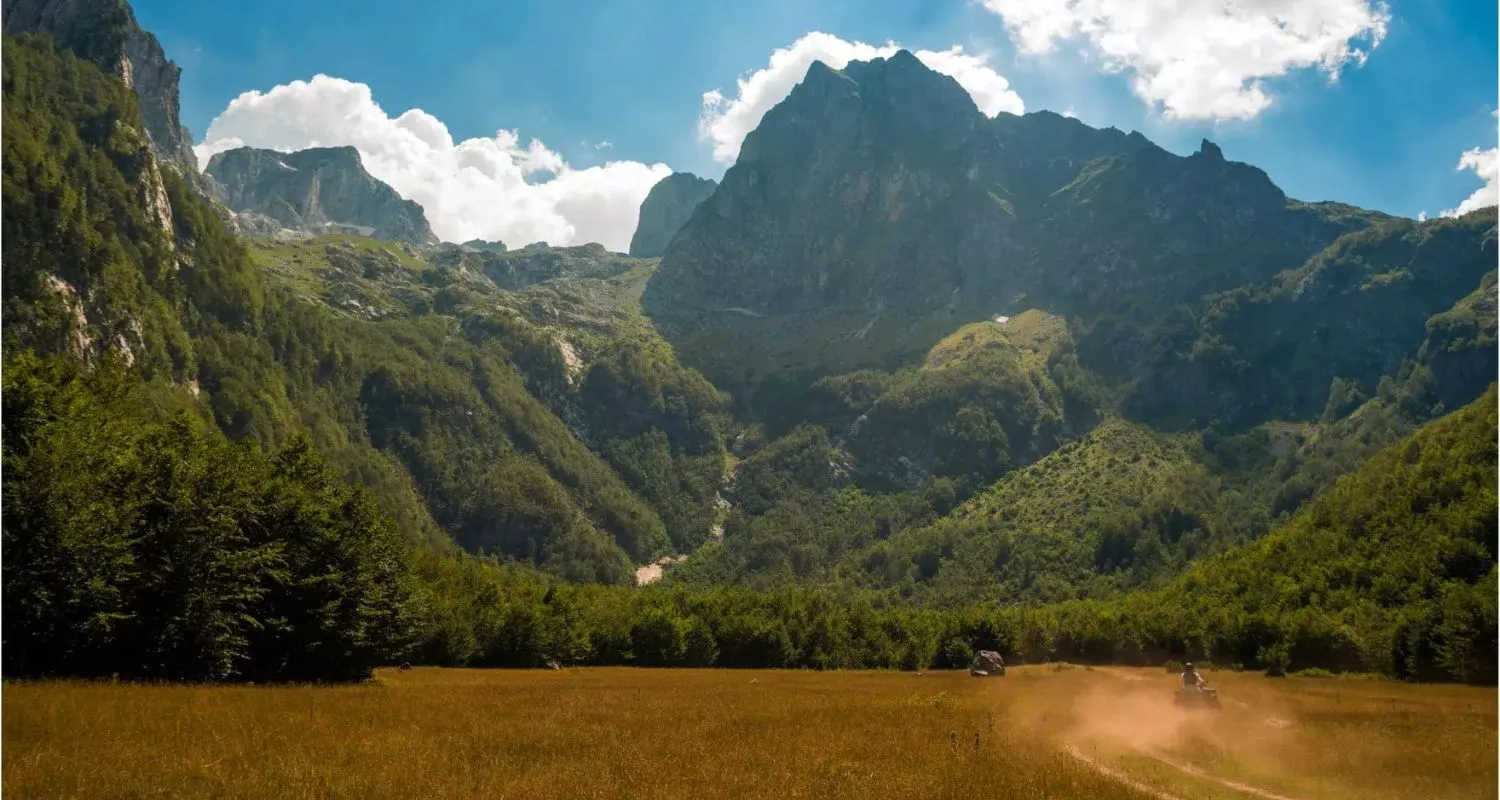 Dirt road through Grebaje Valley beneath steep mountain peaks
