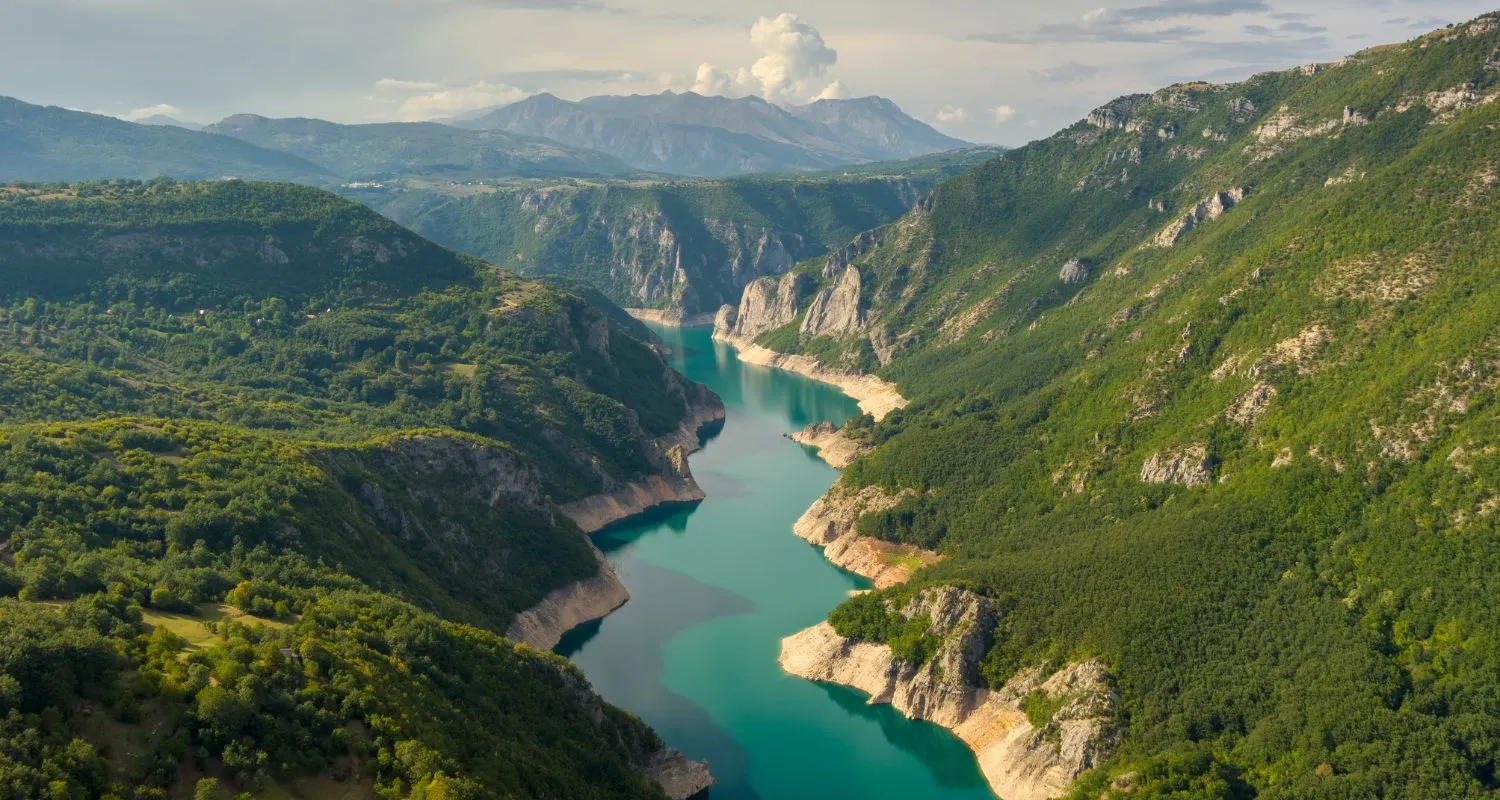 : Piva Lake canyon with turquoise water between high green mountain slopes