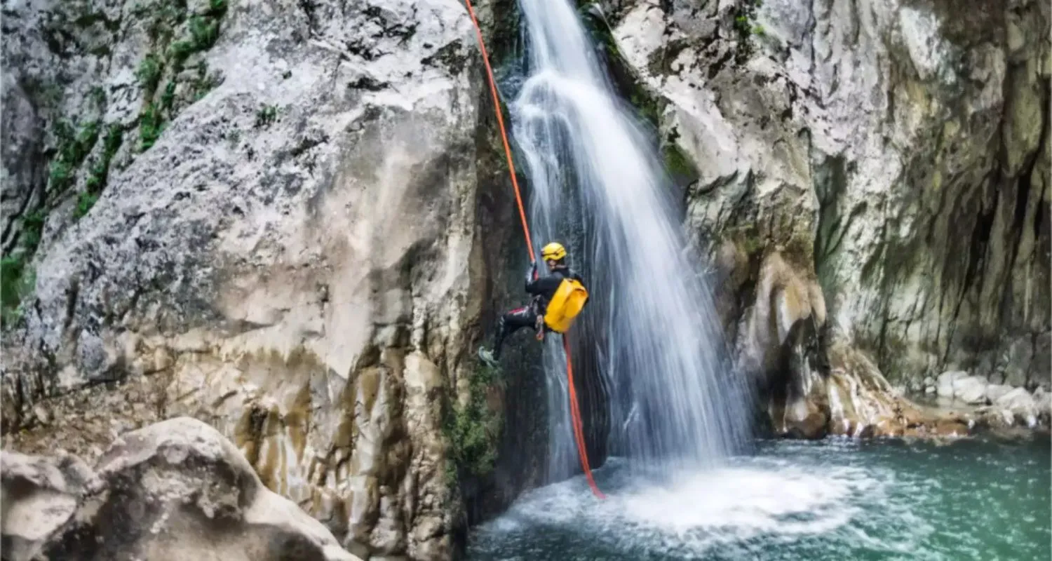 Canyoner descending a waterfall inside Nevidio Canyon using rope and safety gear