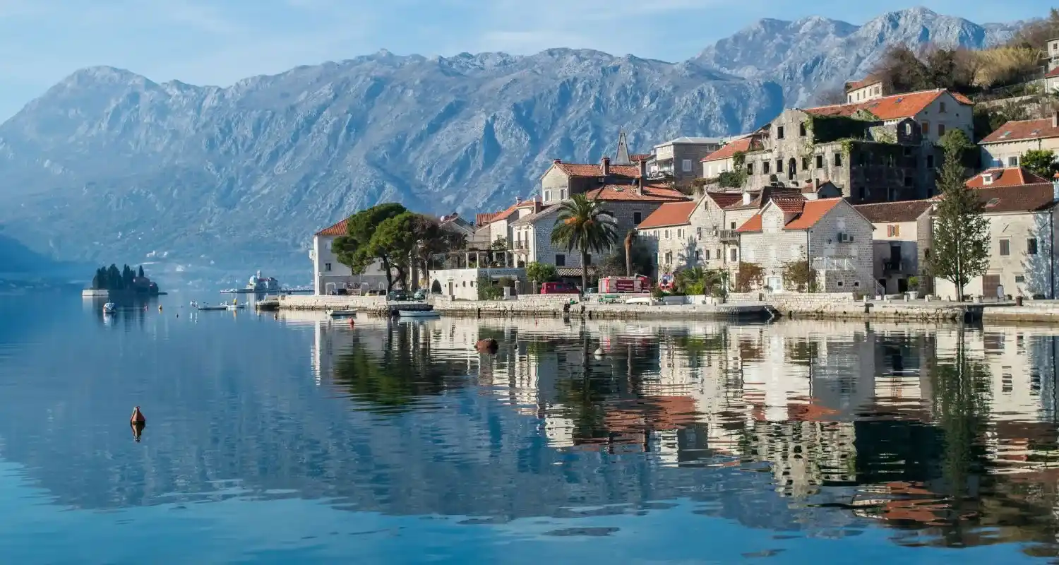 Perast sa odrazom u mirnoj Boki Kotorskoj i otočićem Gospa od Škrpjela u pozadini