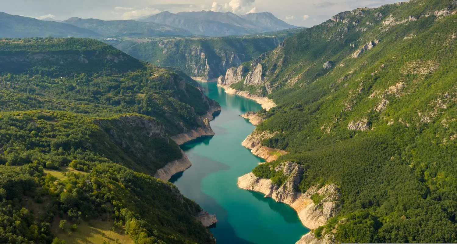 Turquoise waters of Piva Lake winding between forested mountain slopes