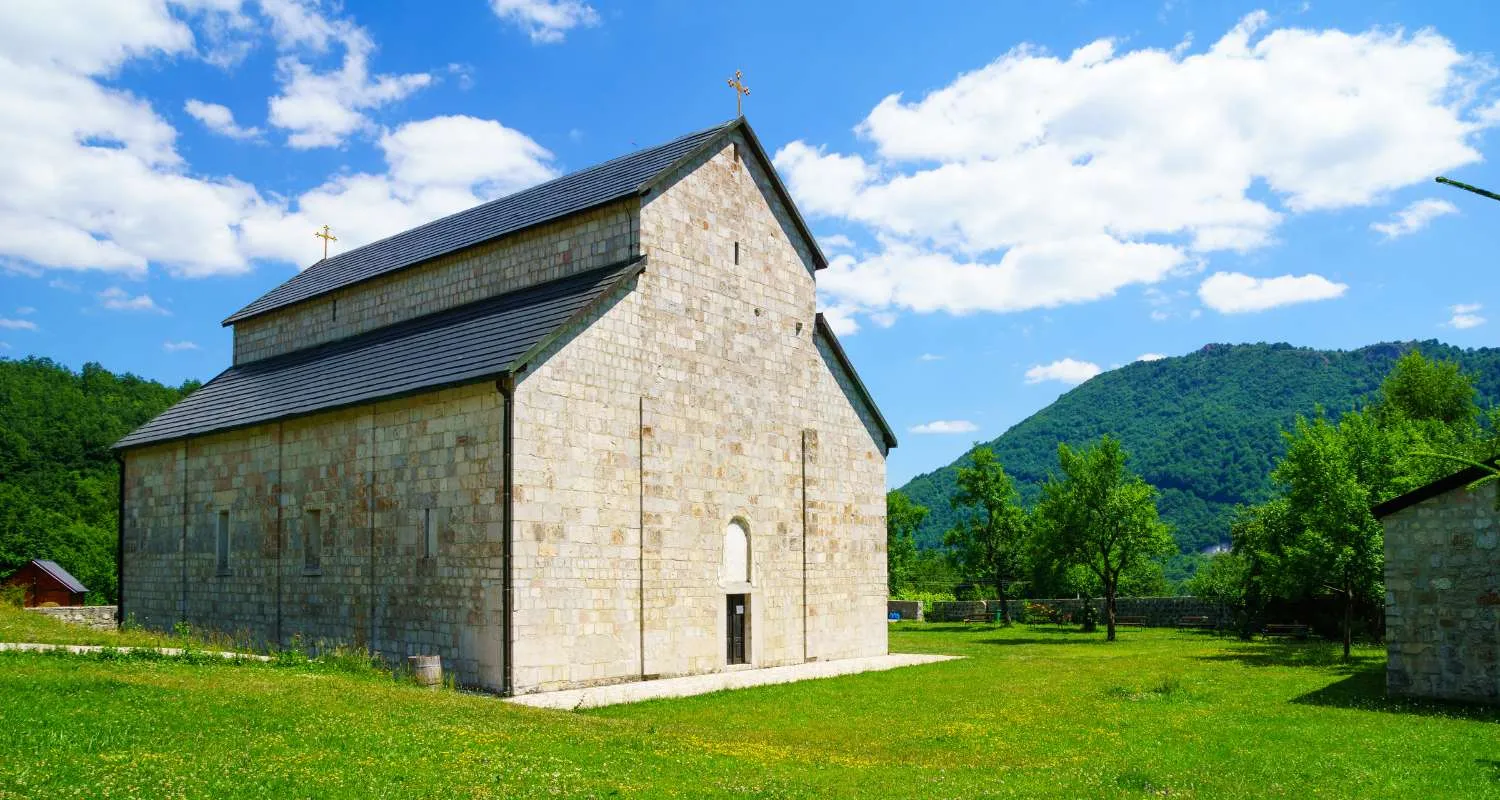 Piva Monastery surrounded by greenery and mountains near Piva Lake
