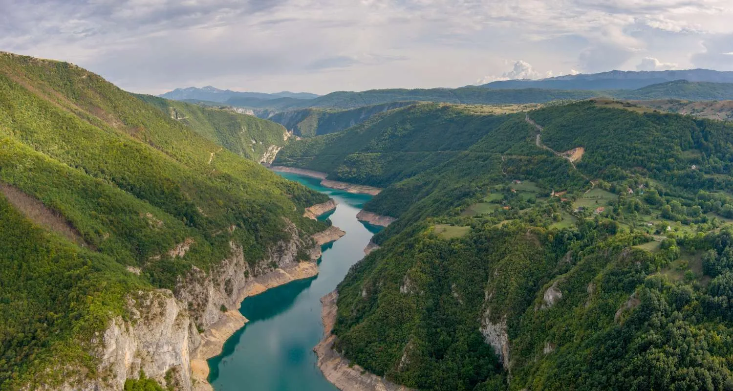 Piva Lake through a narrow canyon surrounded by forests, mountain slopes and rural landscapes