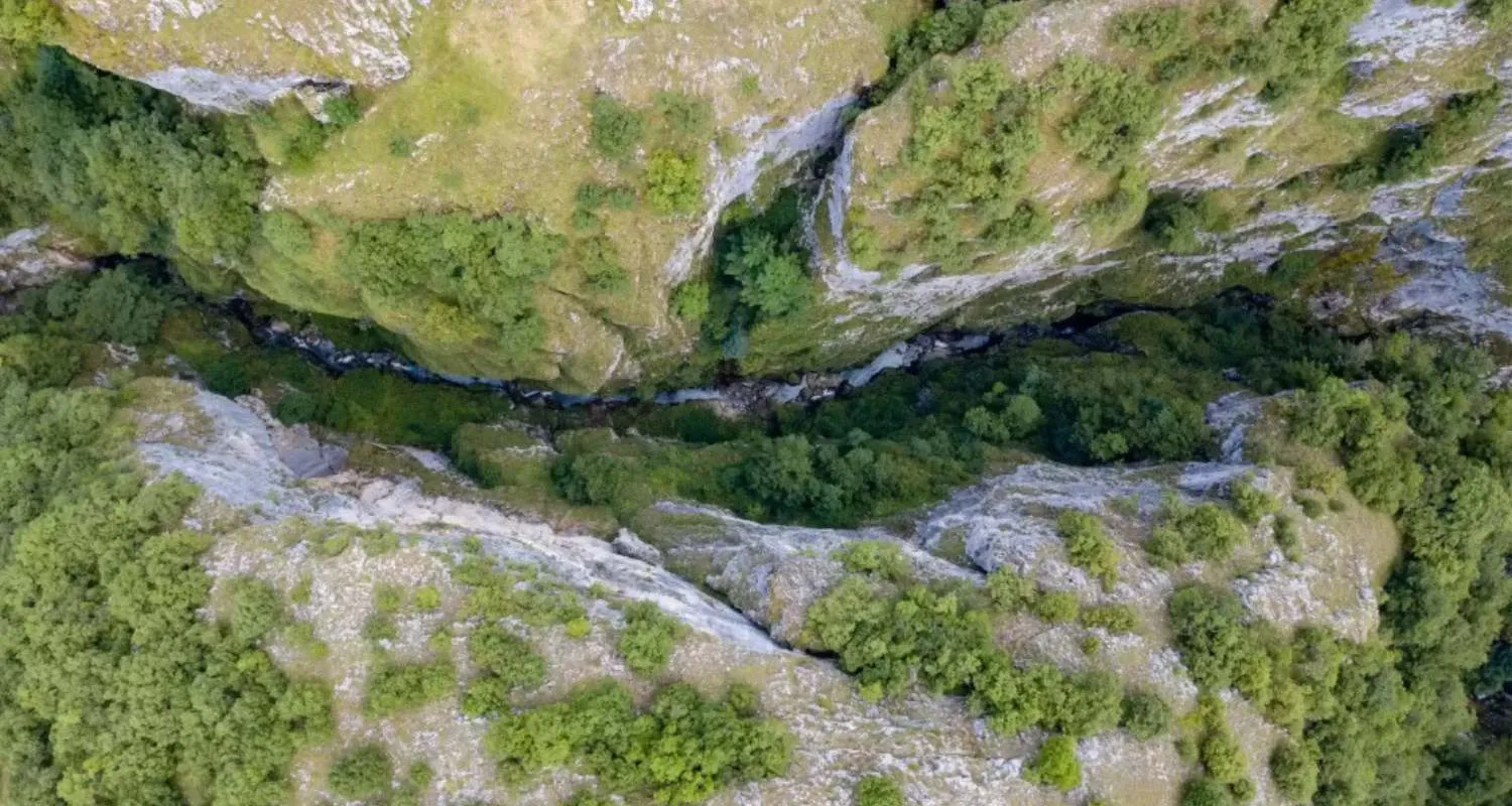 Narrow river corridor cutting through Nevidio Canyon surrounded by steep limestone walls