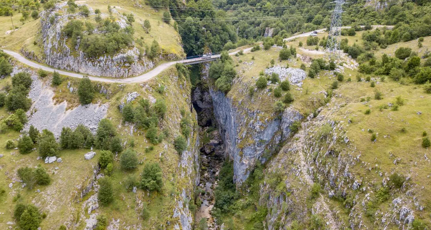 Deep rocky gorge of Nevidio Canyon with narrow canyon floor and road bridge above