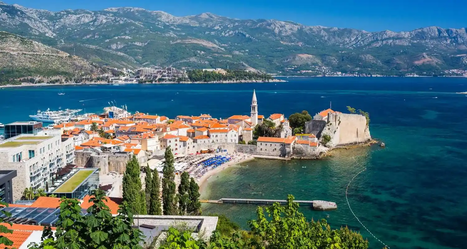 Stari grad Budva sa narandžastim krovovima i tirkiznim Jadranskim morem, jedno od najposjećenijih mjesta svih koji putuju u Crnu Goru
