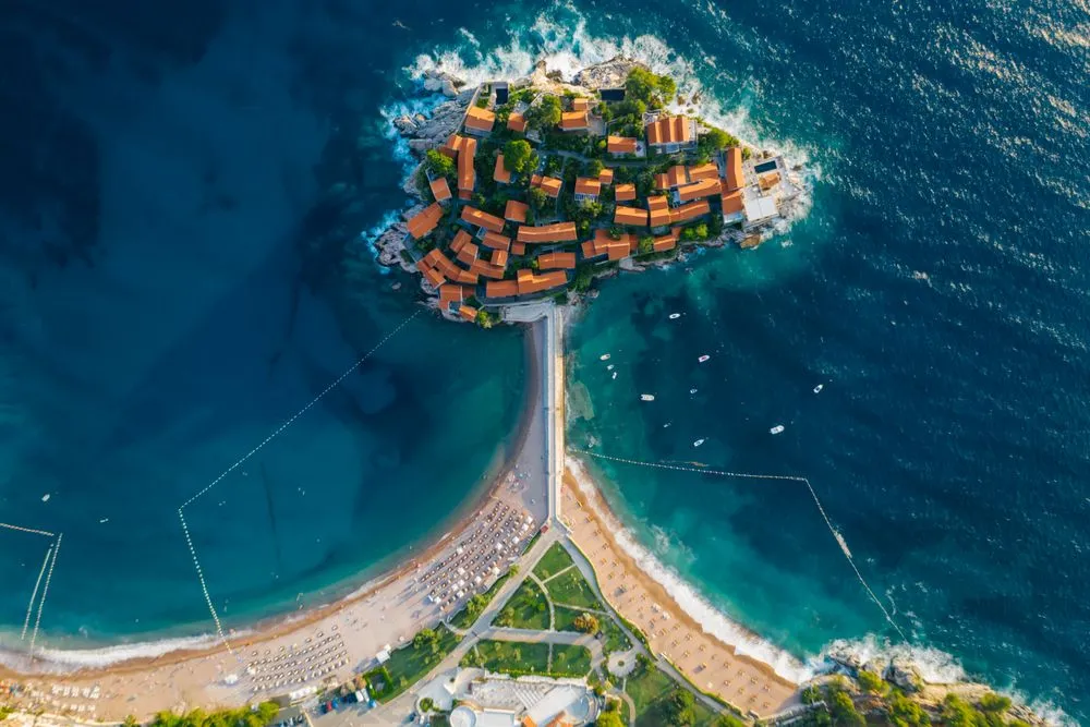 Pogled iz vazduha na Sveti Stefan, jedno od najljepših mjesta za posjetiti u Crnoj Gori, sa pješčanim plažama okruženo morem.