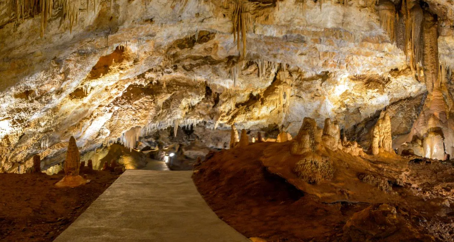 Uređena staza kroz Lipsku pećinu okružena stalaktitima, stalagmitima i osvijetljenim kamenim svodovima