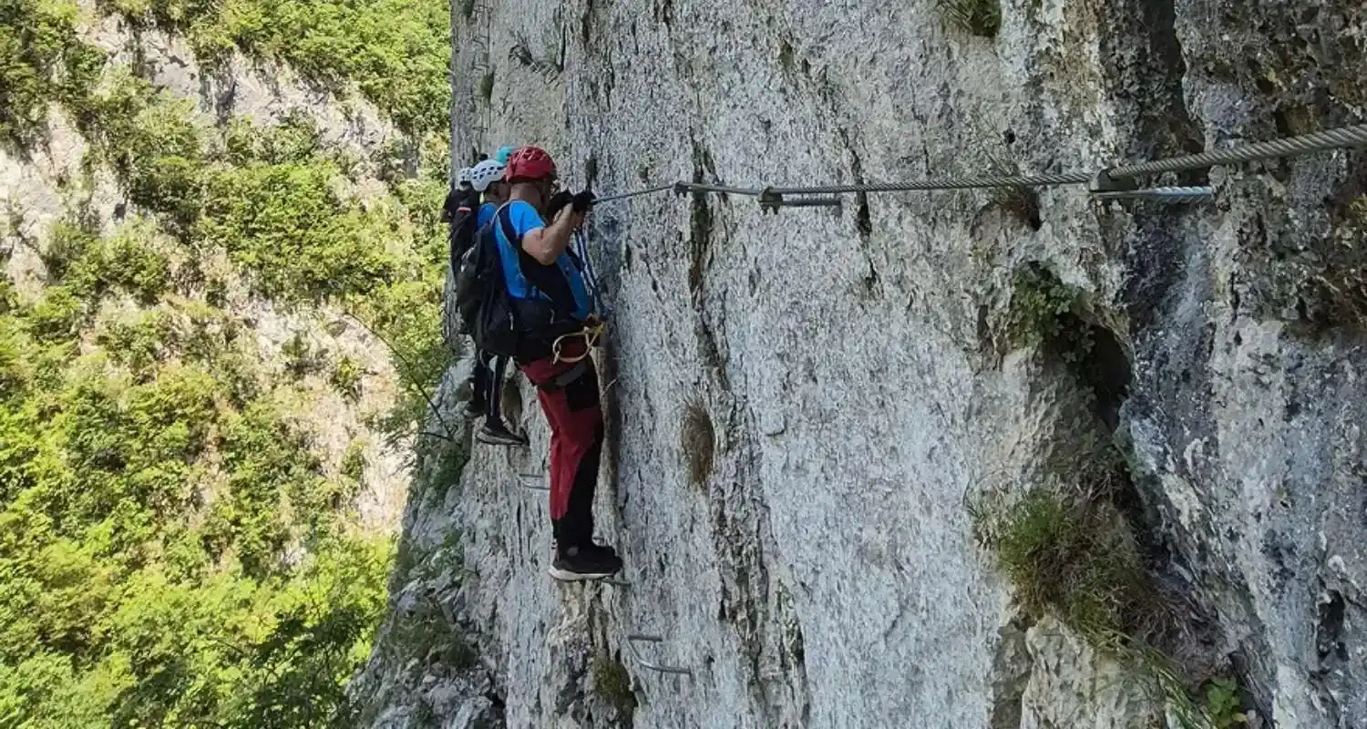 Hikers on the secured Via Ferrata route above the Piva Canyon